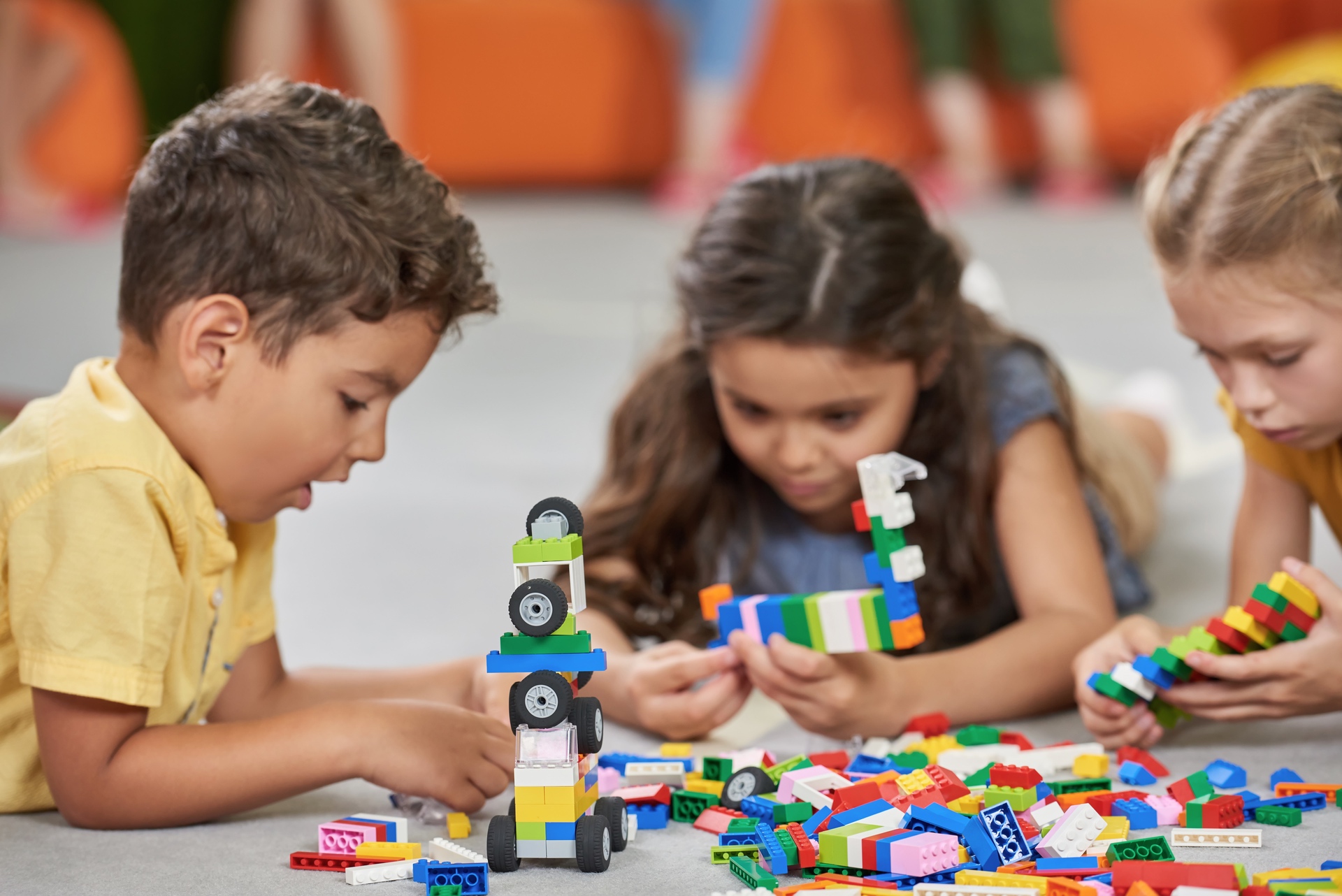 3 young children playing with lego.